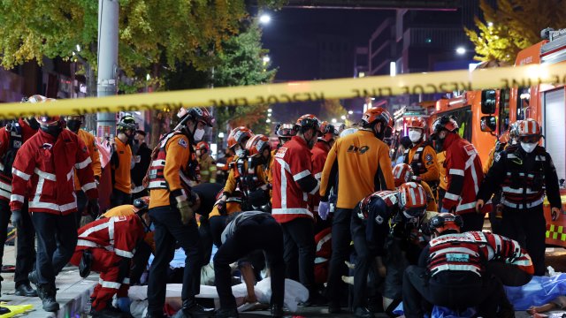 Rescue workers and firefighters work on the scene of a crushing accident in Seoul, South Korea.