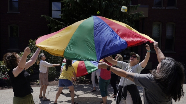 Teachers launch a ball from a small parachute during a workshop helping teachers find a balance in their curriculum
