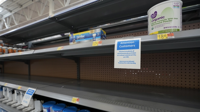 Shelves typically stocked with baby formula sit mostly empty at a store.