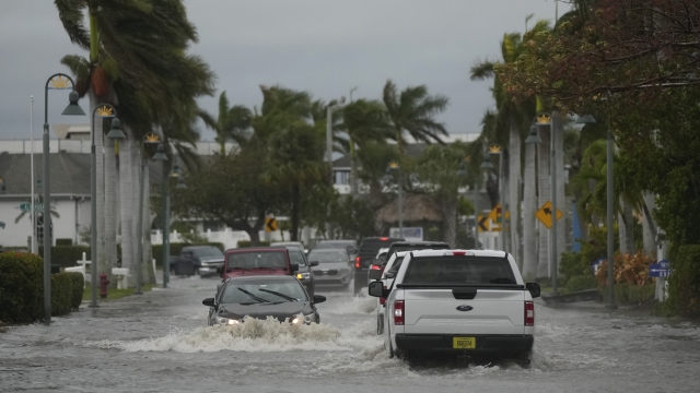 Drivers navigate a flooded Florida street following the passage of Hurricane Nicole