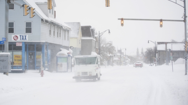 A postal truck makes its way down Grant Street during a snowstorm.