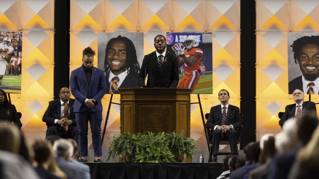 A football player speaks to a crowd during a memorial service in Charlottesville, Virginia