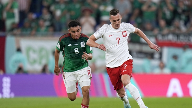 Poland's Arkadiusz Milik, right, and Mexico's Carlos Rodriguez, battle for the ball during the World Cup