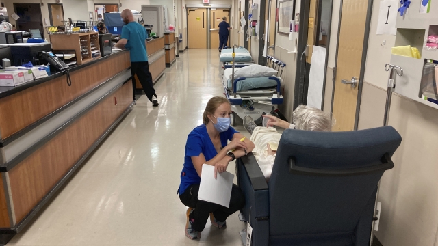 A nurse talks to a patient in a hospital emergency room.