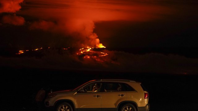 alks on a phone in his car alongside Saddle Road as the Mauna Loa volcano erupts.