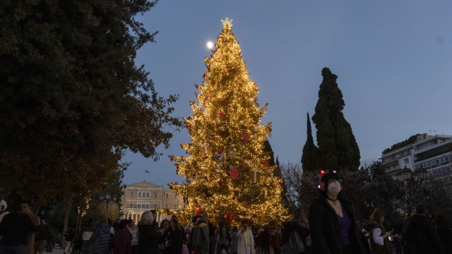 People walk around the Athens Christmas tree at central Syntagma square in Athens