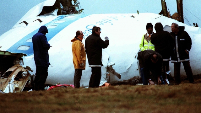 Unidentified crash investigators inspect the nose section of the crashed Pan Am flight 103.