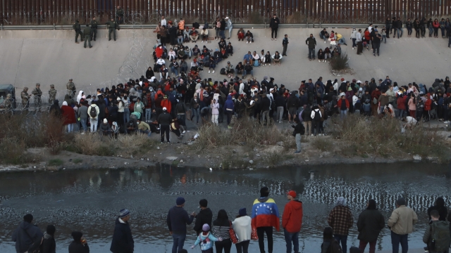 Migrants gather at a crossing into El Paso, Texas, as seen from Ciudad Juarez, Mexico.