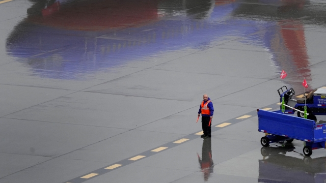 A Southwest Airlines ground operations crew member waits to guide an arriving jet