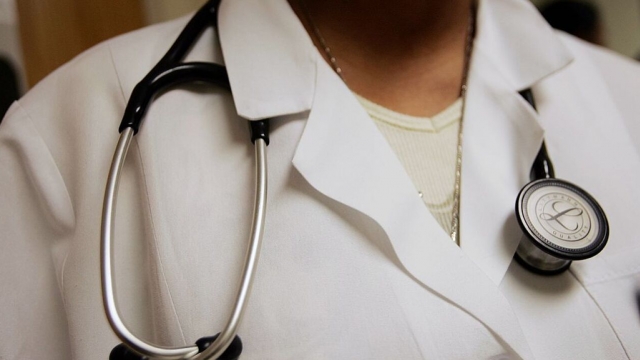 A doctor's stethoscope is seen worn around her neck