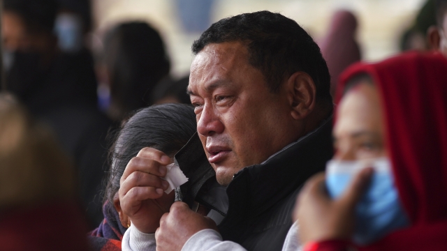 A man cries as he waits to receive the body of a victim of a plane crash, at a hospital in Pokhara, Nepal