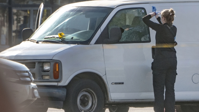 A forensic photographer gets ready to take pictures of a van's window and its contents in Torrance, California.