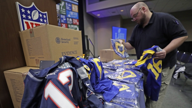 Bill Hardy, with Homeland Security Investigations, unpacks some of the counterfeit items seized for NFL Super Bowl 53.