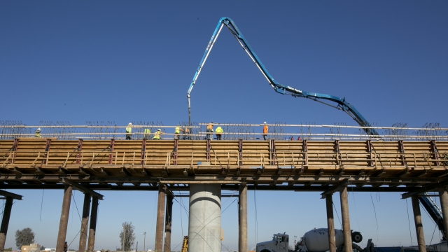 workers pour concrete on to one of the elevated sections of the high-speed rail that will cross over the San Joaquin River
