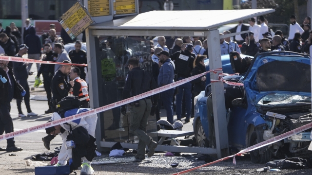 Israeli police work at the site of a car-ramming attack at a bus stop.