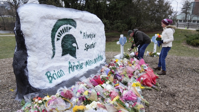 Mourners leave flowers at The Rock on the grounds of Michigan State University in East Lansing, Mich.