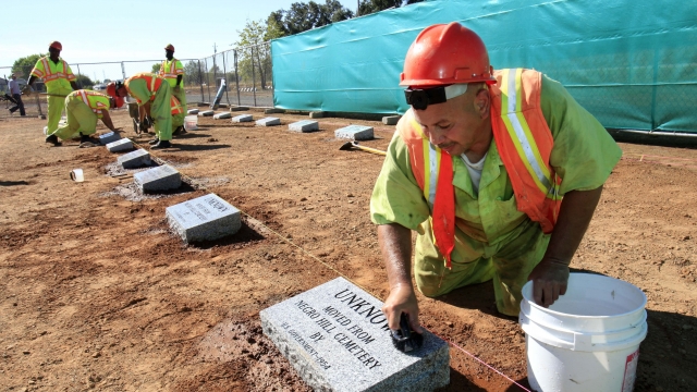 A California prison inmate cleans a newly installed headstone.