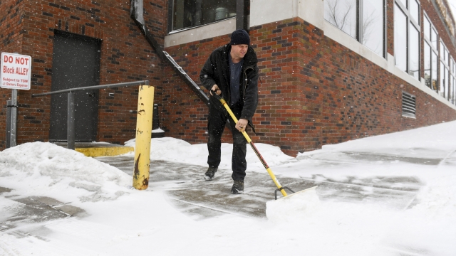Man shoveling snow on a sidewalk.