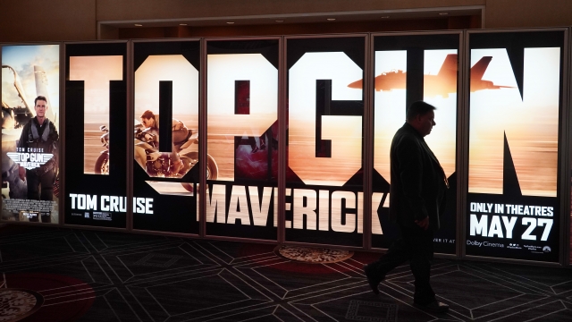 A CinemaCon attendee walks past a "Top Gun: Maverick" advertisement.