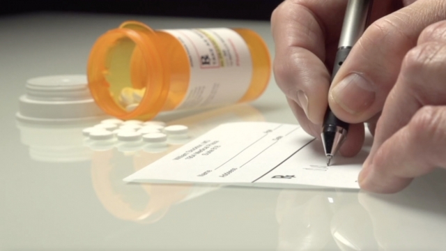 Person writing a prescription.