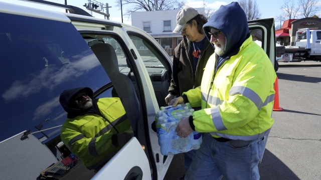 A volunteer helps load water into a car in East Palestine, Ohio.