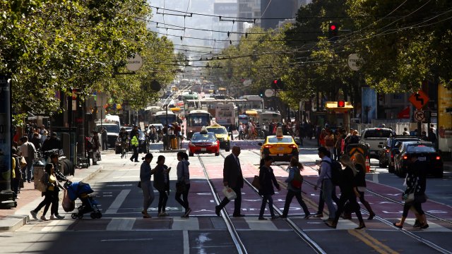 Pedestrians cross Market at Fourth St. in downtown San Francisco.