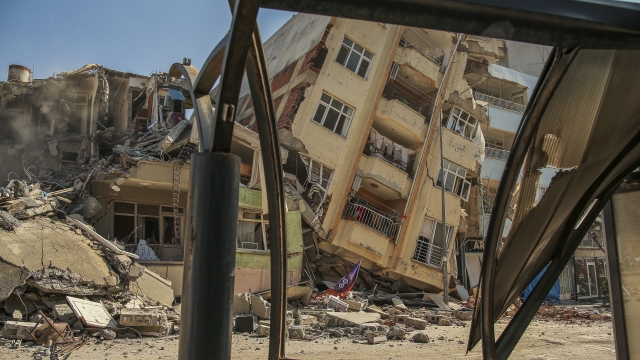 A destroyed building leans on a neighbouring house following the earthquake in Samandag, southern Turkey.