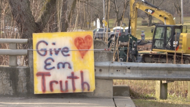 A sign near a clean up truck says "Give 'em truth"