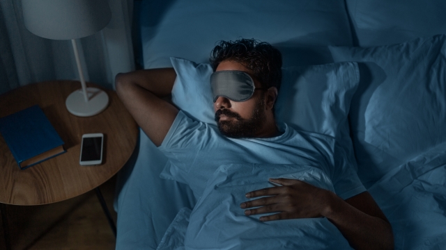 Man with blindfold sleeping.