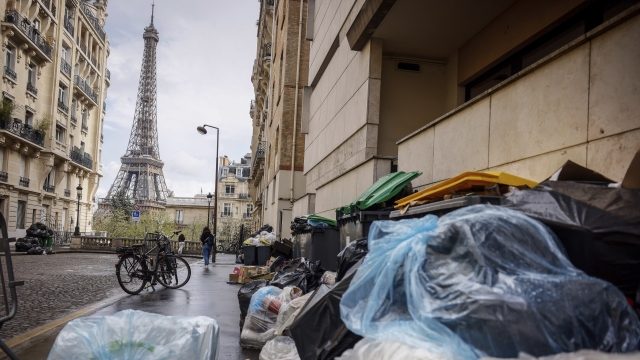 Uncollected garbage pile is on a street near the Eiffel Tower in Paris