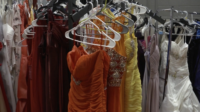 Prom dresses hang on a rack.