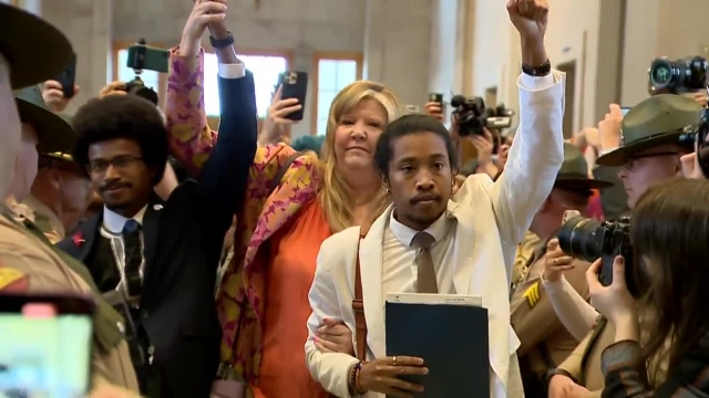 Tennessee state lawmakers Justin Pearson, left, Gloria Johnson and Justin Jones raise their hands.