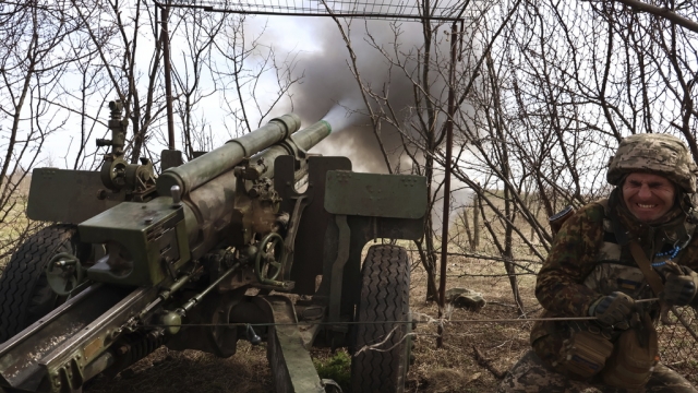 A Ukrainian soldier fires the howitzer at the Russian positions on the frontline.