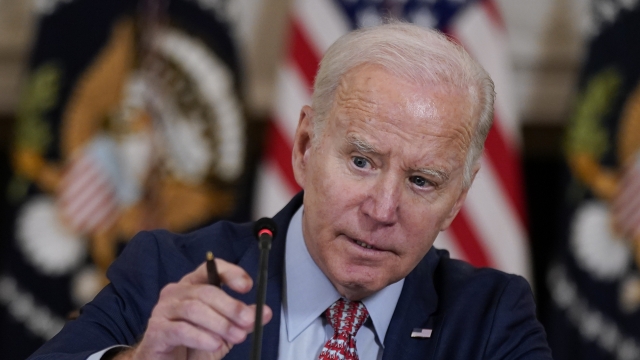 President Joe Biden adjusts his microphone during a meeting