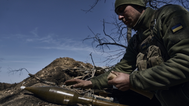 A Ukrainian soldier prepares to fire a grenade launcher on the frontline in Bakhmut