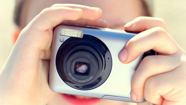 A person holds a digital camera.