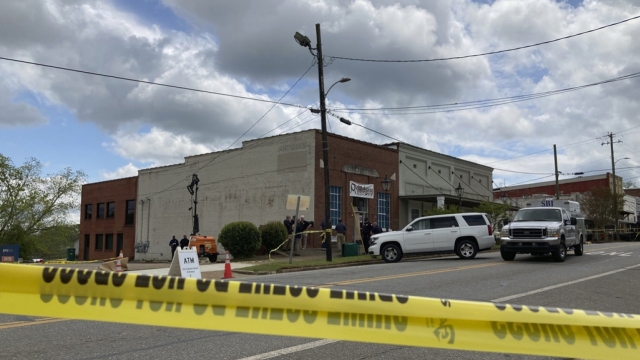 Investigators work at the site of a fatal shooting in downtown Dadeville, Alabama