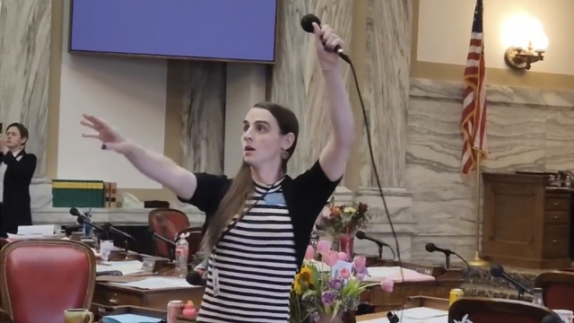 Montana Democratic Rep. Zooey Zephyr hoists a microphone into the air.