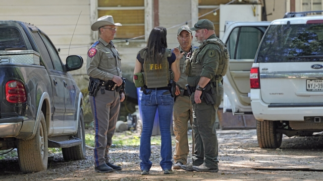 Law enforcement officials work Sunday, April 30, 2023, in the neighborhood where a mass shooting occurred Friday night.