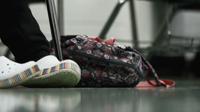 A child's feet next to a backpack
