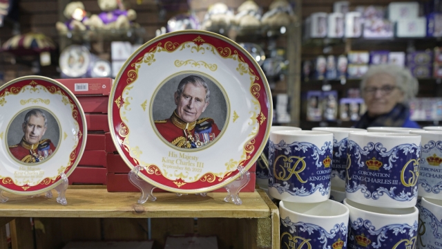 King Charles III coronation plates and mugs are displayed for sale in a gift shop in London.