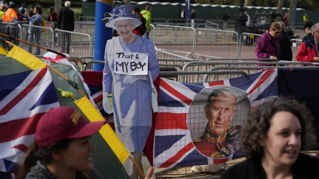 A cardboard cut out of the late Queen Elizabeth II on display as people camp along the King's Coronation route