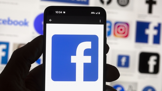 The Facebook logo is seen on a cell phone.
