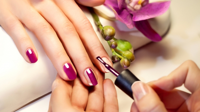 Woman with purple nails getting a manicure.