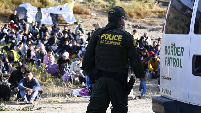 Asylum seekers wait between the double fence on U.S. soil along the U.S.-Mexico border near Tijuana, Mexico.