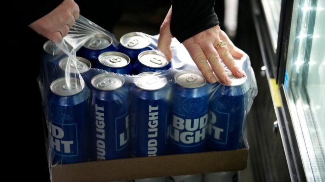A stadium worker opens a case of Bud Light beer.