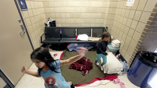 Venezuelan immigrant girls play in the Chicago Police Department's 16th District station where families have taken shelter