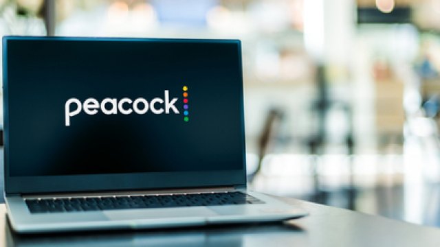 Laptop displays the Peacock logo.