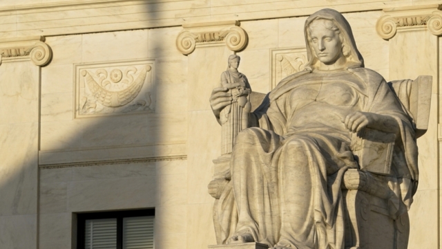 The United States flag casts a shadow on the Supreme Court building