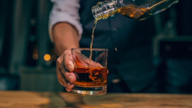 Bartender pouring a glass of whiskey.